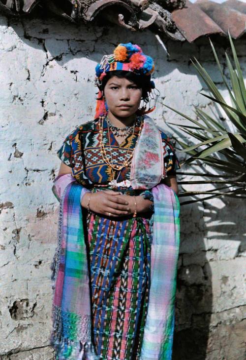 A young girl dressed in traditional clothing leans against a wall in Guatemala, November 1926.Photog