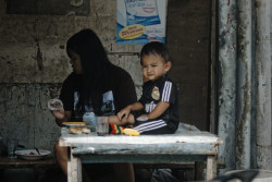 Kid looks on as his mother feeds him. Bandung,