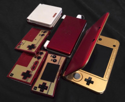 tinycartridge:  Custom Famicom 3DS XL ⊟ WayForward’s James Montagna put together this rad Famicom-color 3DS XL using, it looks like, a Zelda 3DS XL and a red one. It’s pictured here among his other Famicom-style handhelds and some business card