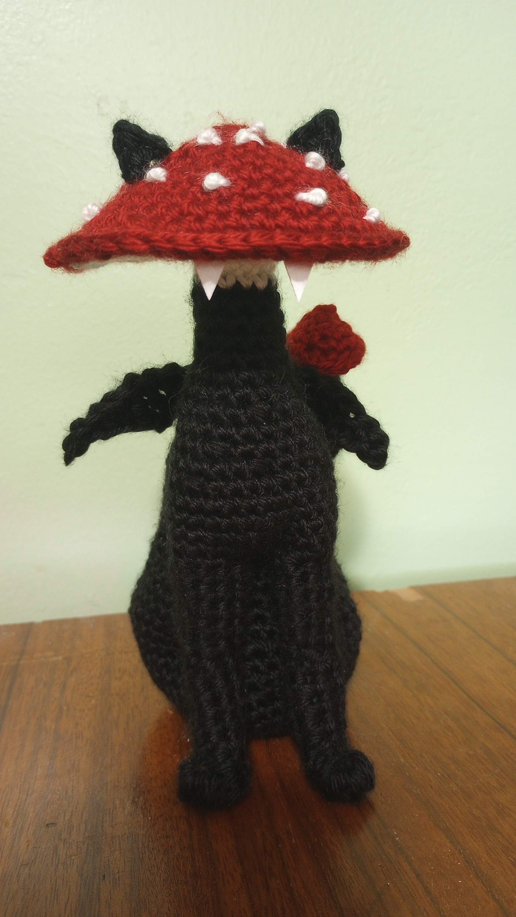 crocheted black cat with a red spotted mushroom for a head