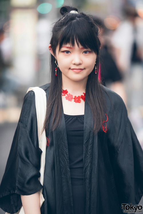 Yui on the street in Harajuku wearing a long black dragon coat over a black top, wide leg Uniqlo pan