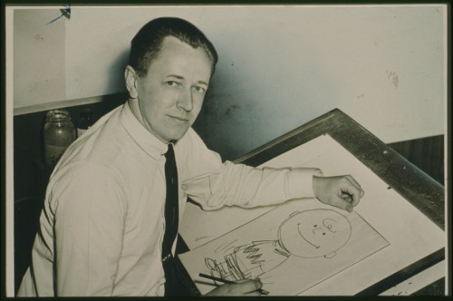 The creator of the popular Peanuts comic strip Charles Schultz poses with a drawing of his