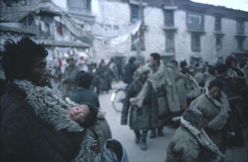 dolm: Tibet. Lhasa. 1981. A father carries his child inside his thick sheepskin overcoat. Hiroj