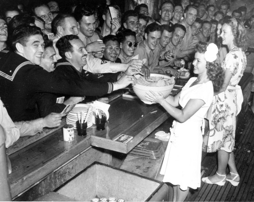 Shirley Temple, now a United Service Organizations (USO) volunteer, holds a bowl of cookies for serv