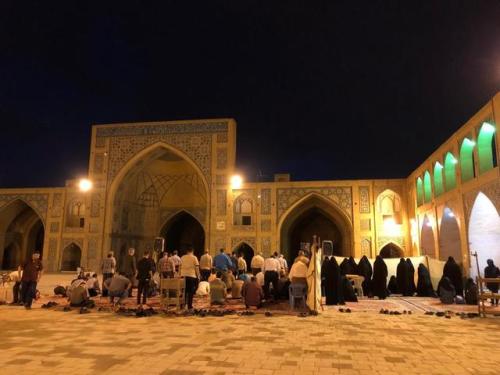 Women and men pray next to each other, with a partition, in the courtyard of Isfahan’s Jameh Mosque 