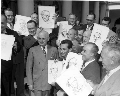 Harry S. Truman is surrounded by Harry S. Truman!
The President poses with a group of cartoonists (in Washington to meet with the Newspaper Advisory Committee of the U. S. Treasury) and the sketches they drew during their meeting.
-from the Truman...