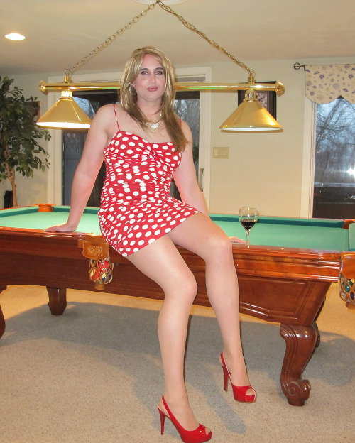 Amateur crossdresser in tan pantyhose and a red dress. Her nylon feet shod in high-heeled shoes.Amat