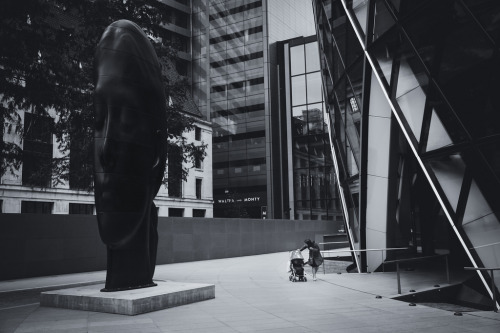 PeekabooWoman with child in pushchair walking past “Laura”, a cast iron sculpture by Jau