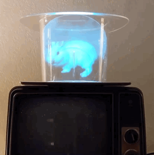 a gif of a cyan hologram of a rabbit appearing in a glass above a tv.
