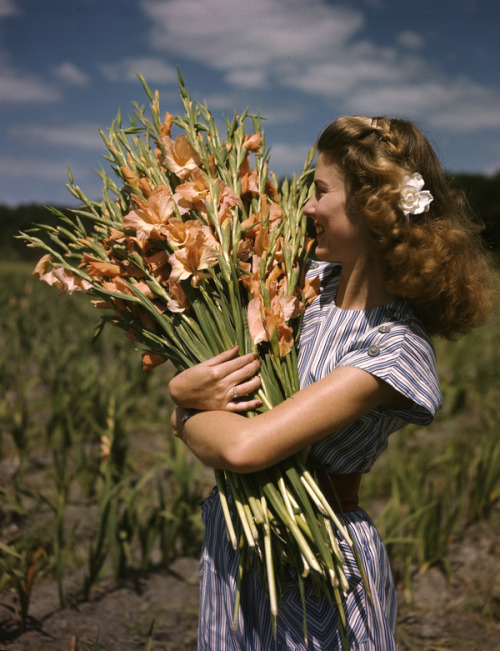 notinthehistorybooks - Unidentified woman holding gladiolus at...