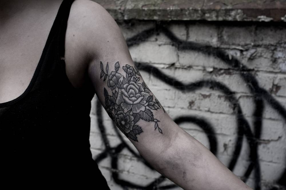 Smoke stamp tattoo located on the upper arm.