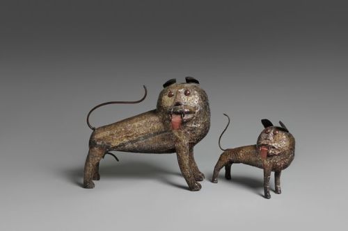 Two Fon LionsBenin.Each covered with sheet brass with hammered fur, red painted projecting tongues, 