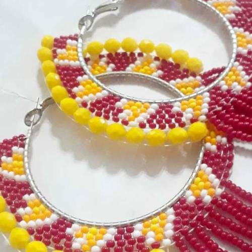 Hoops made with dark red, yellow, white, and orange seed beads with dangle loops and edged with larg