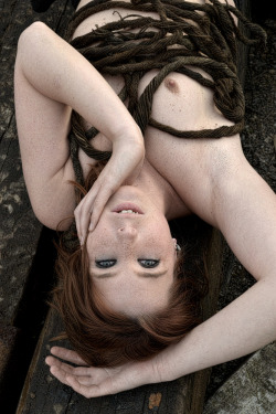 Lovely ginger redhead staring up at you with pretty eyes.  Not sure what the rope is for.