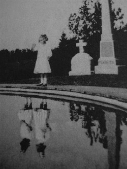 beautyandmadness:  Photograph, taken in 1925 of a girl visiting the grave of her twin sister who died in a house fire the year before. Parents of the girl saw her, on many occasions, talking to her sister like she was playing in her room, but no one was