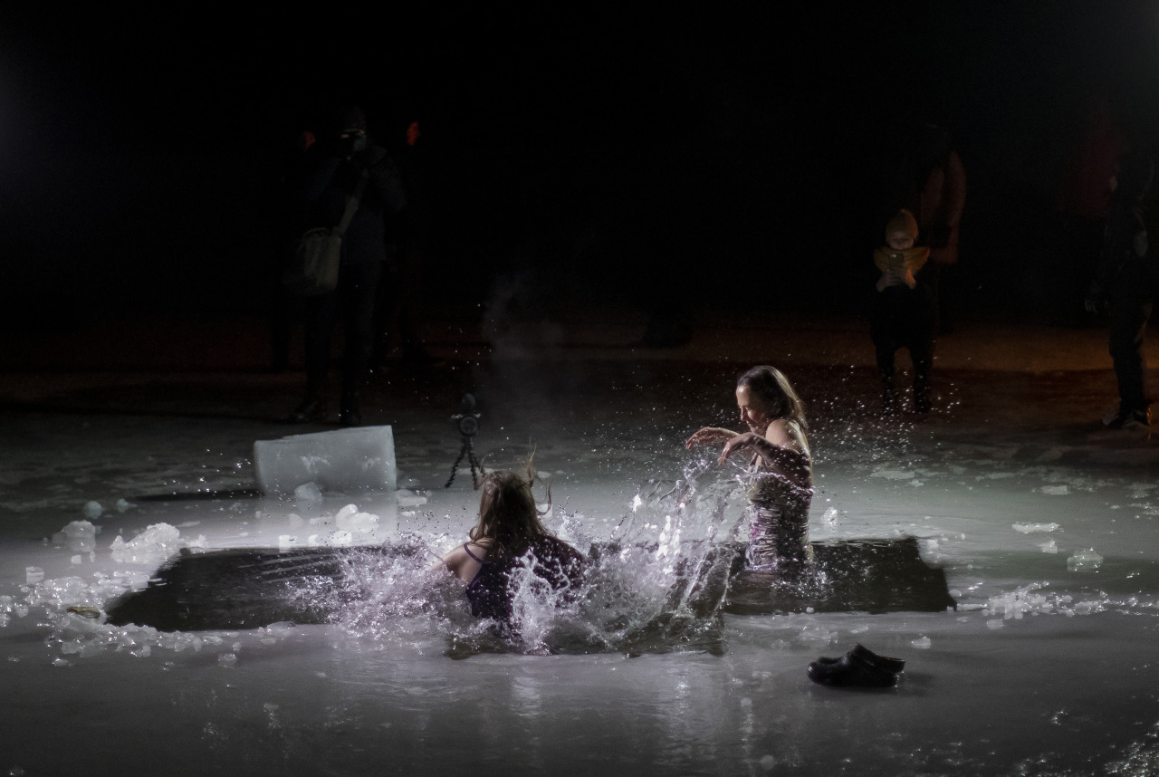 I credenti ortodossi lituani fanno il bagno nell'acqua gelida poco dopo la mezzanotte durante una tradizionale celebrazione dell'Epifania in un lago vicino a Vilnius, Lituania, martedì 19 gennaio 2021.
(Foto di Mindaugas Kulbis)