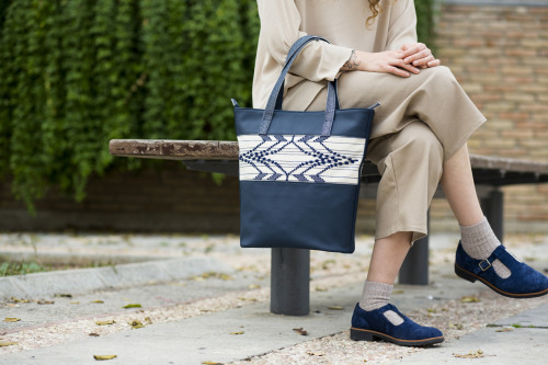 One of the new Schemata shoulder bags with a handwoven geometric pattern and dark blue vegan leather