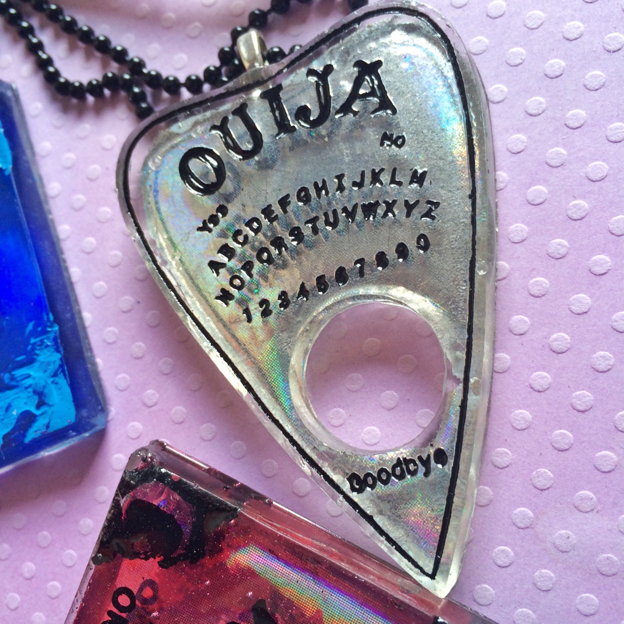 jinxandcurses:  NEW! Holographic ouija boards in planchettes in pink, purple, blue,