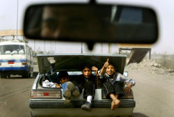 xafat:Boys wave as they ride in the trunk
