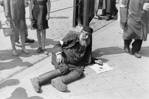 bag-of-dirt:A elderly Jewish man is photographed on the sidewalk of the Warsaw Ghetto. Construction 