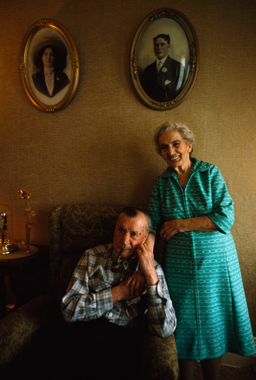 An elderly couple poses beneath their youthful portraits in Virginia City, Nevada, September 1975.Ph