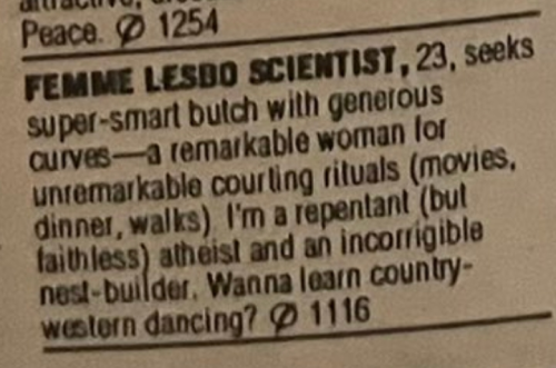 Photo of a newspaper. It reads, "Femme Lesbo Scientist, 23, seeks super-smart butch with generous curves — a remarkable woman for unremarkable courting rituals (movies, dinner, walks). I'm repentant (but faithless) atheist and an incorrigible nest-builder. Wanna learn country western dancing?"