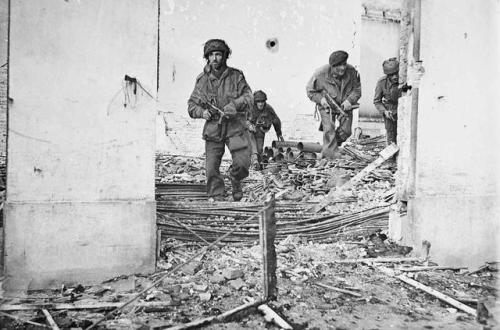historicaltimes: British airborne troops moving through a shell-damaged house in Oosterbeek near Arn
