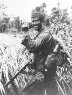 georgy-konstantinovich-zhukov:Vietnam, 1971, an SASR trooper cheerfully greets the cameraman. Note the extensive modifications to the M60 he carries, with the handguard removed, and an SLR pistol-grip placed offset on the barrel. (Australian War Memorial)