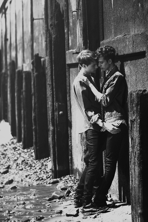 Deux garçons s'embrassent contre un mur