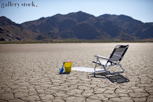Joe McBride: Chair, towel, and shovel set up on a dry lake
