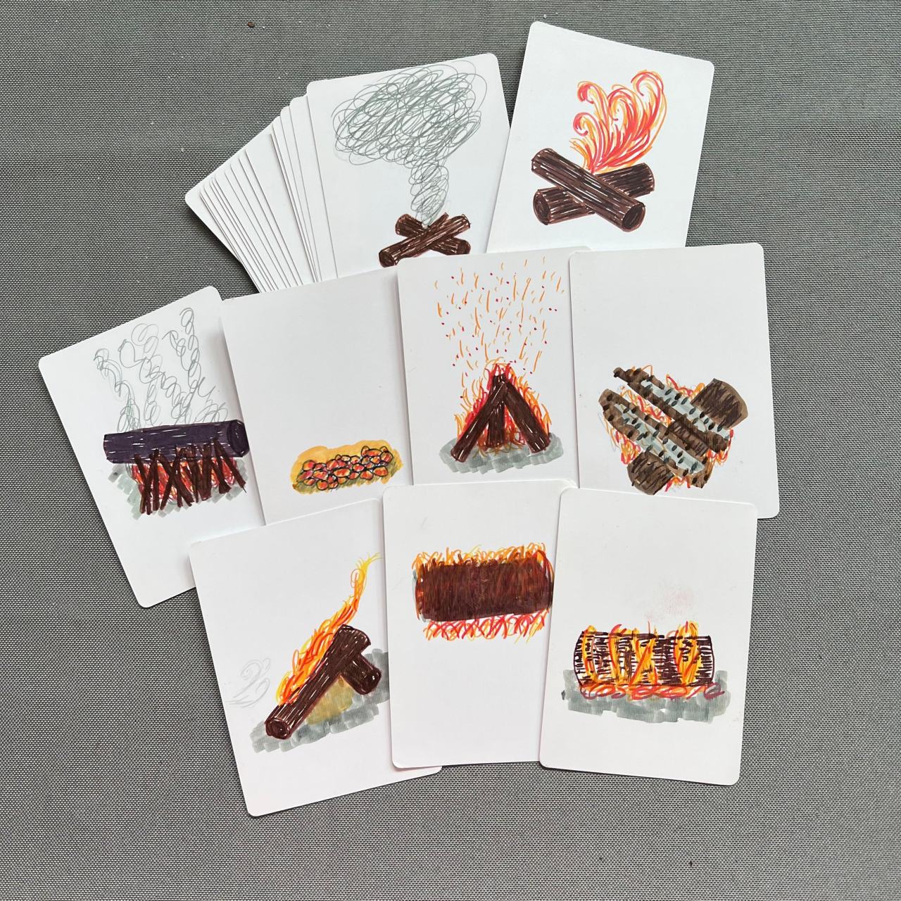 A deck of hand-drawn cards with various aspects of fires on them