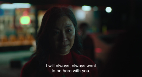A screencap from the film Everything Everywhere All At Once. A middle-aged woman, Evelyn, is speaking to her daughter, Joy, with tears in her eyes. The caption reads: 'I will always, always want to be here with you.'