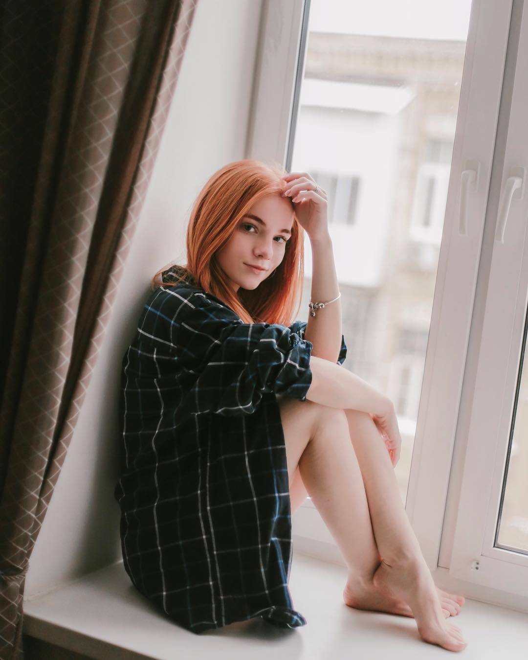 Julia sat at the window wearing only an over-sized flannel shirt that was unbuttoned.