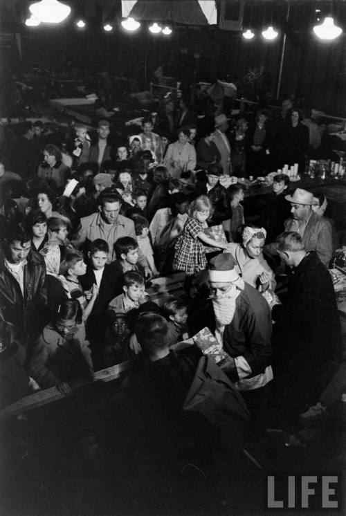 Families forced from their homes by flooding, celebrate Christmas in a shelter(Allan Grant. 1955)
