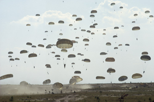 Paratroopers in training land in a dusty field at Fort Bragg, North Carolina, February 1962.Photogra