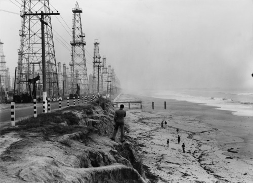 Derricks extract petroleum from wells drilled out under the sea on Huntington Beach in California, J