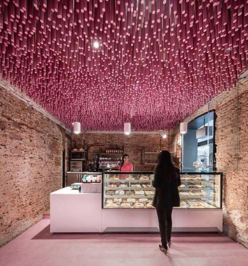 Bakery with 12,000 strawberry lollipops hanging from the ceiling in Alcalá de Henares, Spain via red