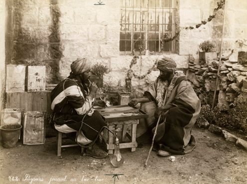 Two men play backgammon and smoke, Syria 