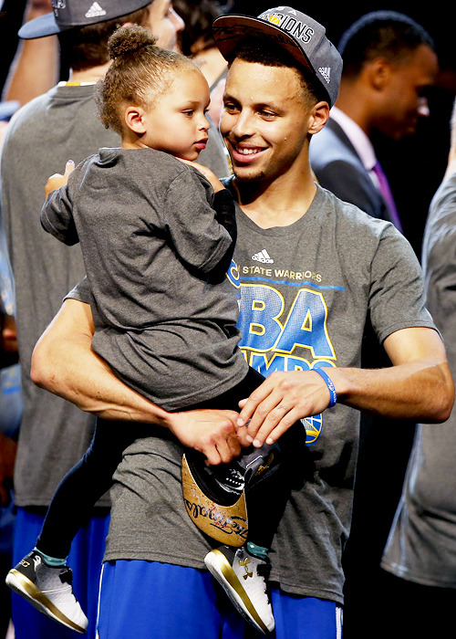 celebritiesofcolor:  Stephen Curry #30 of the Golden State Warriors celebrates with Riley after defeating the Cleveland Cavaliers in Game Six of the 2015 NBA Finals at Quicken Loans Arena on June 16, 2015