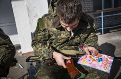 enrique262:  War in Donbass, Ukrainian soldier of the   Azov Battalion  attaching stickers to his magazine, found in an abandoned school that was turned into a battalion HQ close to the battlefield. 