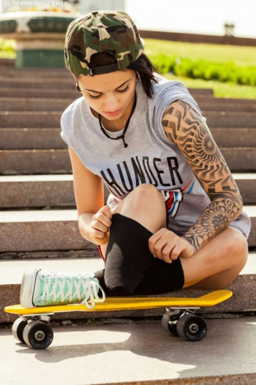 an amputee onelegged girl-skateboarder with tattoo and lightgreen converse sneaker on the only leg p