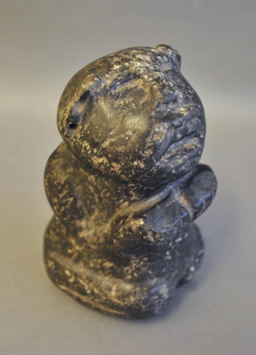 Kneeling human figurine, made of a jade-like stone (Olmec or Aztec,Mexico).  Both earlobes are pierc