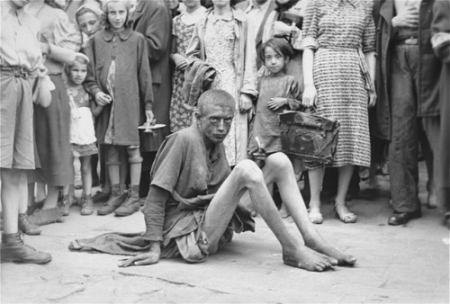 historicaltimes: Starving and filthy a Jewish teenager in the Warsaw Ghetto is surrounded by a crowd