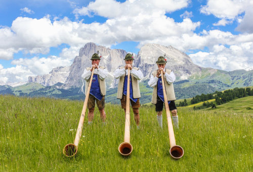 Men playing Alphorns or Alpenhorns (or Alpine horns), a tradition that dates back to the 16th centur