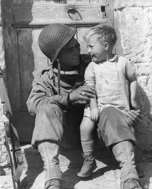 worldwar-two:American soldier Fred Linden sits with a boy from the village of Trévi&egra
