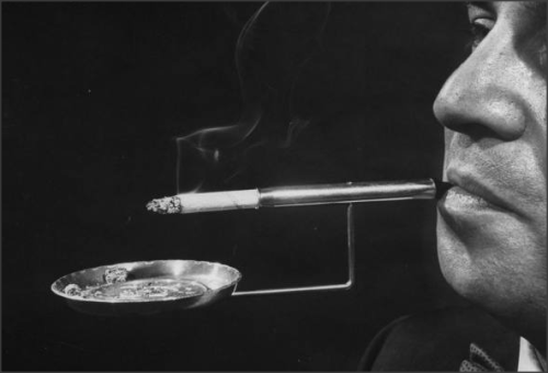  Robert L. Stern, smoking a cigarette from his self-designed ashtray combination cigarette holder. 1