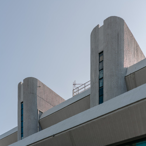 3-storey, horizontally shuttered library with contrasting vertically oriented semi-circular towers, 