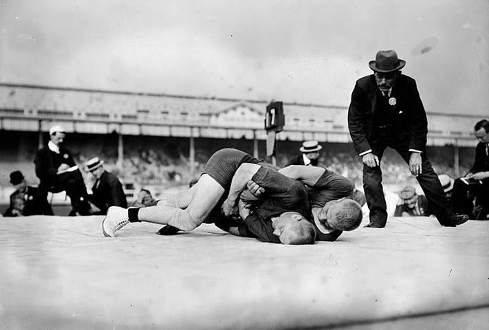 wrestlingroots:  Wrestling during the 1908 Olympics - A referee closely watches the