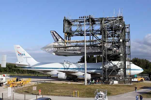 “Space shuttle Discovery is lowered onto the Shuttle Carrier Aircraft in the mate-demate