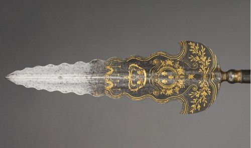 art-of-swords:  Partizans Photo #1 Attributed to Jean Berain I (1640 - 1711) Dated: circa 1670 - 1680 Culture: French Medium: steel, gold and velvet, etched, chiselled and gilded Measurements: blade length: 53.2 cm, straps length: 7.3 cm. Weight: 1.92 kg